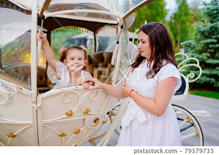 Mom and daughter in the carriage. A fabulous holiday for a child. Mom and daughter in the carriage. A fabulous holiday for a child. 79379733