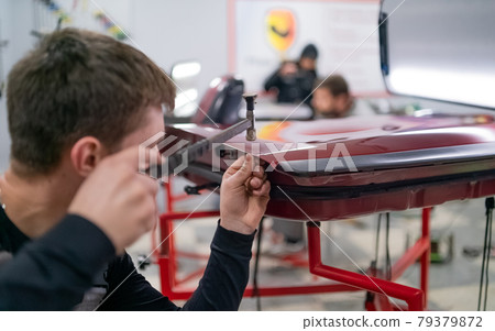 Close shot of dent removing without paint, using rubber hammer  79379872