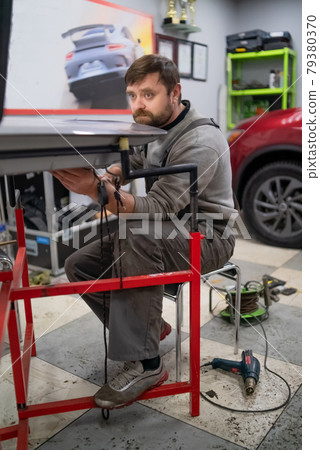 Close shot of dent removing without paint, using rubber hammer  79380370
