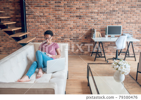 A woman in casual clothes surfing internet while resting at home 79380476