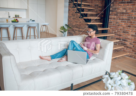 A woman in casual clothes surfing internet while resting at home 79380478
