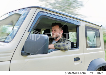 Handsome middle-aged man, driver driving car, looking forward at road Handsome middle-aged man, driver driving car, looking forward at road 79381024