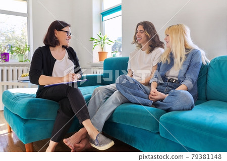 Professional female social worker, teacher, counselor, psychologist talking with teenagers 79381148
