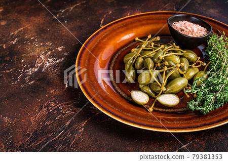 Marinated canned Capers berries in a rustic plate. Dark background. Top view. Copy space Marinated canned Capers berries in a rustic plate. Dark background. Top view. Copy space 79381353