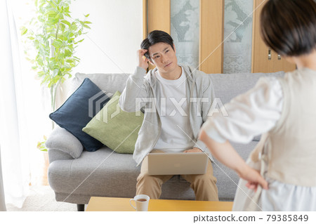 Husband scolded by his wife in the living room at home Husband scolded by his wife in the living room at home 79385849