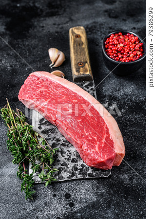 Fresh Raw top sirloin beef meat steak on a butcher cleaver. Dark wooden background. Top view Fresh Raw top sirloin beef meat steak on a butcher cleaver. Dark wooden background. Top view 79386299
