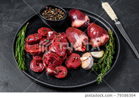 Sliced Raw turkey hearts ready for cooking. Black background. Top view Sliced Raw turkey hearts ready for cooking. Black background. Top view 79386304