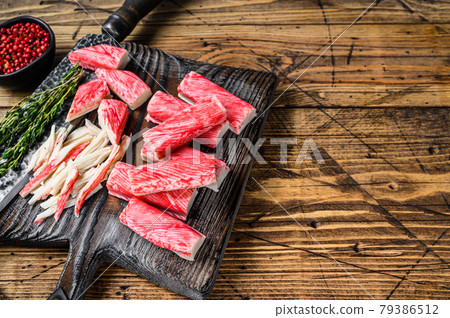 Sliced Crab sticks and meat on a wooden cutting board. wooden background. Top view. Copy space Sliced Crab sticks and meat on a wooden cutting board. wooden background. Top view. Copy space 79386512