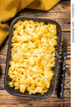 Baked Mac and cheese American dish with Cheddar sauce. Wooden background. Top view Baked Mac and cheese American dish with Cheddar sauce. Wooden background. Top view 79386655