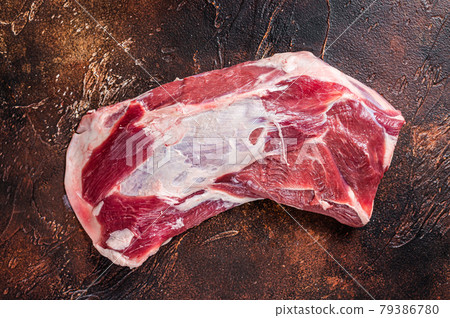 Raw lamb mutton shoulder meat on the bone. Dark background. Top view Raw lamb mutton shoulder meat on the bone. Dark background. Top view 79386780