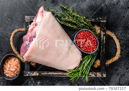 Fresh Raw pork Eisbein knuckle ham in a wooden tray with meat knife. Black Wooden background. Top view Fresh Raw pork Eisbein knuckle ham in a wooden tray with meat knife. Black Wooden background. Top view 79387157