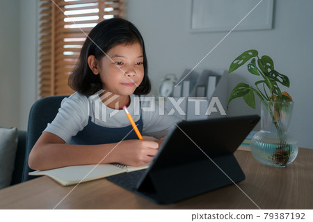 Asian little girl do homework and learning online via the internet tutor on tablet digital night Asian little girl do homework and learning online via the internet tutor on tablet digital night 79387192