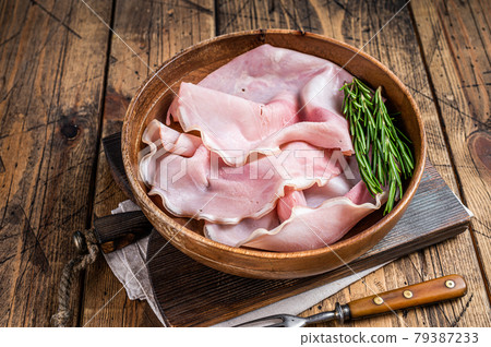 Sliced Prosciutto ham in a wooden plate. wooden background. Top view 79387233