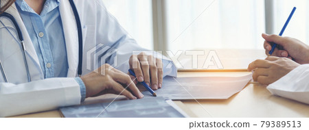 Two asian women doctors discuss meeting doctor's office medical clinic looking x-ray film consulting patient disease. Asian medical lab young women talking together discussing healthcare teamwork 79389513