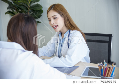 Two asian women doctors discuss meeting doctor's office medical clinic looking x-ray film consulting patient disease. Asian medical lab young women talking together discussing healthcare teamwork Two asian women doctors discuss meeting doctor's office medical clinic looking x-ray film consulting patient disease. Asian medical lab young women talking together discussing healthcare teamwork 79389515