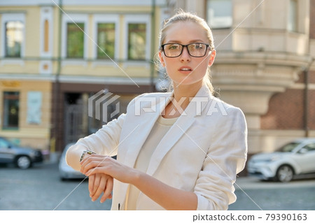 Young successful business woman looking at her wristwatch 79390163