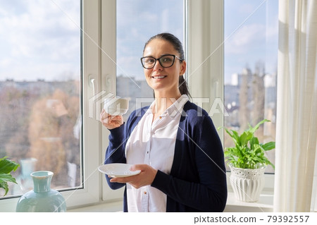 Beautiful business woman in glasses, with cup of coffee near window 79392557