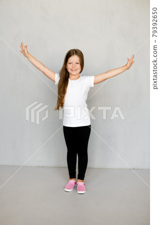 Cute young child with long hair in white t-shirt and black sweatpants Cute young child with long hair in white t-shirt and black sweatpants 79392650
