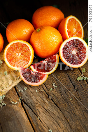 Sliced Sicilian Blood oranges fruits over old dark wooden background. Top view. 79393145
