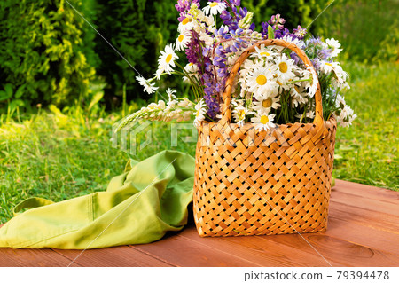 Beautiful summer flowers in a basket on a wooden patio Beautiful summer flowers in a basket on a wooden patio 79394478
