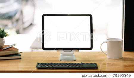 Portable workspace with blank screen tablet on wooden desk with copy space and decorations in coffee shop. 79395549