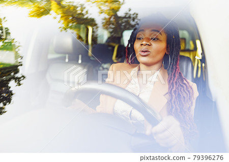 Emotional black woman sitting in a car Emotional black woman sitting in a car 79396276