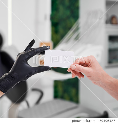 Closeup of two hands giving a business card 79396327