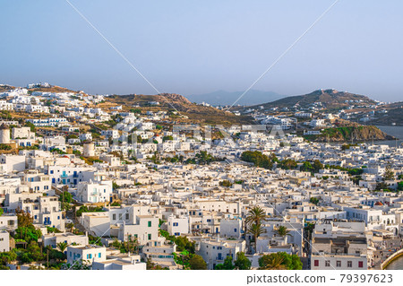 Beautiful view of Chora town of Mykonos at sunset, Greece. Whitewashed houses, hills, greenery, seafront, famous windmills. Beautiful view of Chora town of Mykonos at sunset, Greece. Whitewashed houses, hills, greenery, seafront, famous windmills. 79397623
