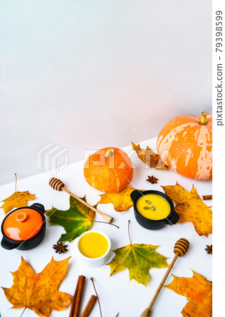 Autumn food. Pumpkin puree soup, leaves. Autumn harvest, pumpkins, leaves on grey as abstract background. Thanksgiving day. 79398599