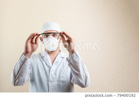 Doctor in goggles and a mask, on a light background. Doctor in goggles and a mask, on a light background. 79400192