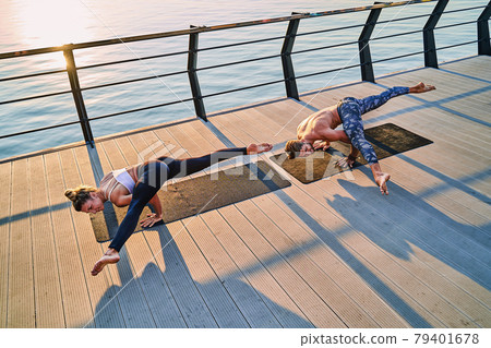 Couple doing practicing yoga together on nature outdoors . Morning exercises at the sunrise. 79401678