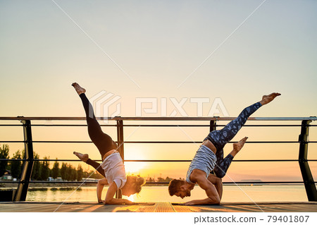 Couple doing practicing yoga together on nature outdoors . Morning exercises at the sunrise. 79401807