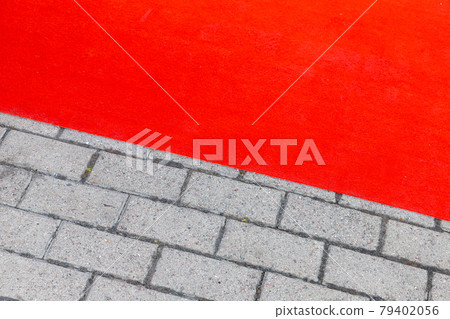 Red carpet lays over gray cobbled road, background Red carpet lays over gray cobbled road, background 79402056
