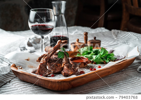 Grilled lamb loin on a wooden plate with wine 79403768