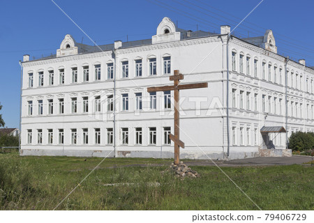 Worship cross in commemoration of all of lost temples of the city of Belozersk on background the industrial-pedagogical college Belozersky Kremlin Worship cross in commemoration of all of lost temples of the city of Belozersk on background the industrial-pedagogical college Belozersky Kremlin 79406729