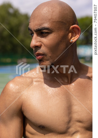 Close-up portrait of young, handsome man posing at street public stadium, sport court or palyground outdoors. Summer sport games. Close-up portrait of young, handsome man posing at street public stadium, sport court or palyground outdoors. Summer sport games. 79407807