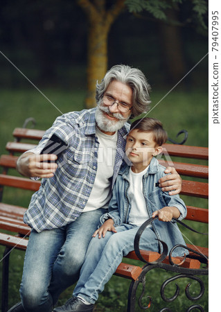 Grandfather with grandchild sitting in a summer park 79407995