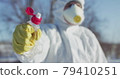 Man in protective costume and glove constricts plastic bottle 79410251