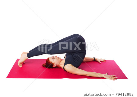 Pilates or yoga. A slender athletic girl performs the exercise reverse twisting of the spine. Mind 79412992