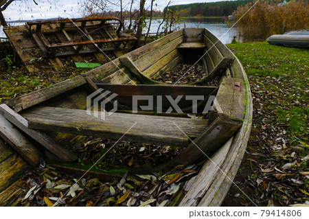 on the shore an old wooden boat in autumn. 79414806