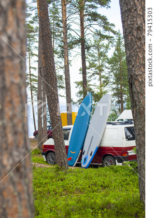 Sup board and cars are parked by the water. Supsurfing, water sport for active outdoor weekend. Sup board and cars are parked by the water. Supsurfing, water sport for active outdoor weekend. 79415303
