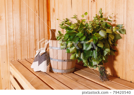 Traditional old Russian bathhouse SPA Concept. Interior details Finnish sauna steam room with traditional sauna accessories basin birch broom scoop felt. Relax country village bath concept. Traditional old Russian bathhouse SPA Concept. Interior details Finnish sauna steam room with traditional sauna accessories basin birch broom scoop felt. Relax country village bath concept. 79420540