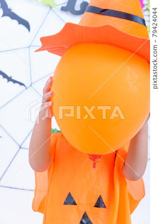 Funny happy kid boy in Halloween costume with Jack and have orange balloon on hand 79424044