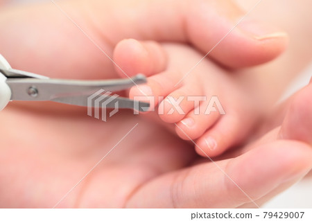 Mom cutting newborn toenails 79429007