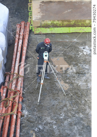 Construction site foundation work Workers who measure height 79430274