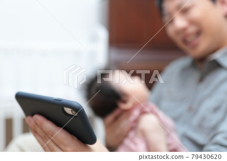 爸爸抱著剛出生的嬰兒,舉起智能手機 爸爸抱著剛出生的嬰兒,舉起智能手機 79430620