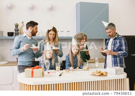 Family celebrating birthday of their grandmother in the kitchen 79430651