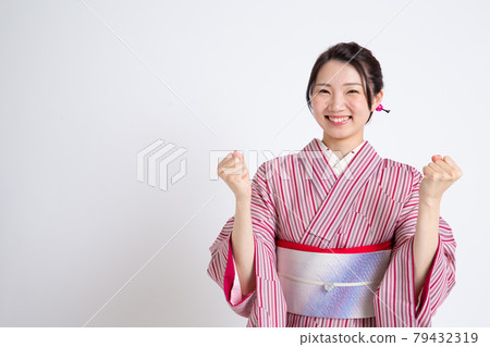 一個年輕的日本女人戴著小冠，做著膽子的姿勢 79432319