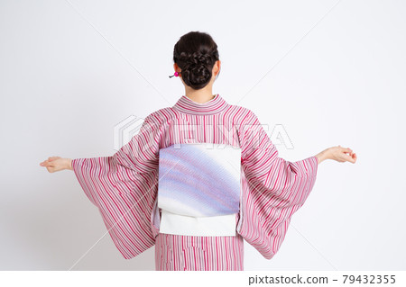 一個年輕的日本女人戴著小冠,伸手 一個年輕的日本女人戴著小冠,伸手 79432355
