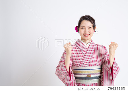 一個年輕的日本女人戴著小冠,做著膽子的姿勢 一個年輕的日本女人戴著小冠,做著膽子的姿勢 79433165